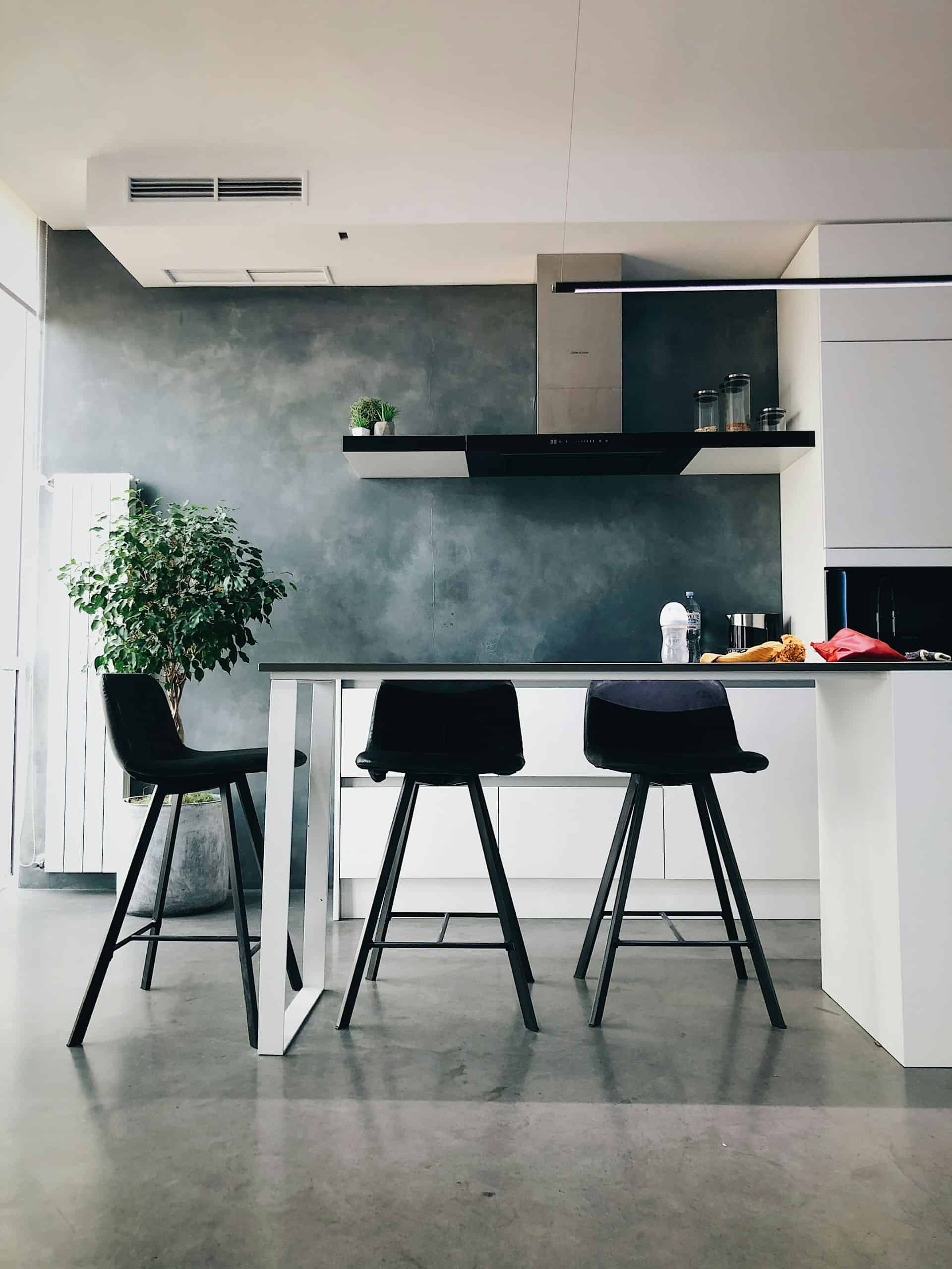 a grey modern kitchen with a kitchen island in the middle